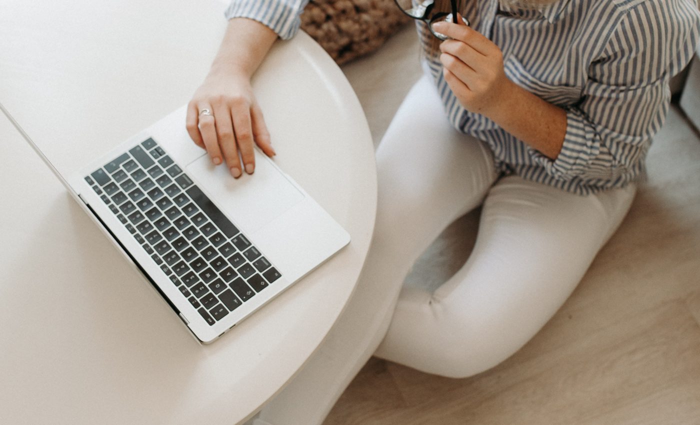 Kobieta siedząca przy stoliku i przeglądająca internet