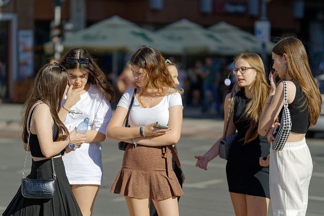 Rozmawiająca i stojąca na ulicy grupa dziewcząt