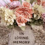 Bukiet wyblakłych sztucznych kwiatów leżących na nagrobku