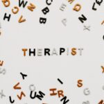 Kolorowe literki ułożone w słowo "therapist" - psycholog czy psychiatra?