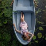 Leżąca kobieta na łódce znajdującej się na wodzie