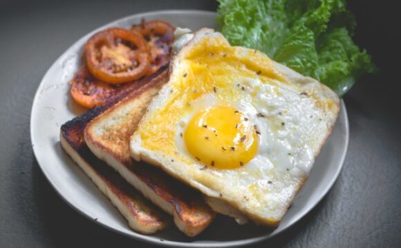 Smaczne śniadanie - pomidor, sałata, tosty i jajko sadzone