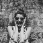 Zdjecie w szarości przedstawiające roześmianą kobietę w okularach