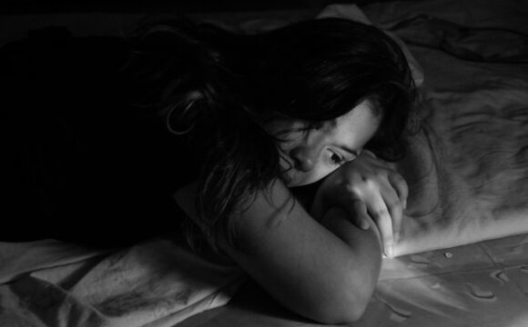 Kobieta leżąca na łózku i odczuwająca poczucie winy