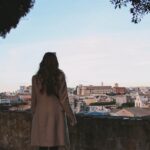 Kobieta w płaszczu patrzy na miasto