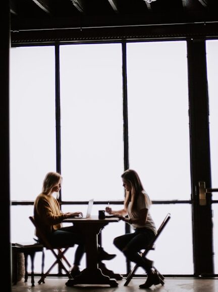 Dwie osoby siedzące przy stoliku i rozmawiajace