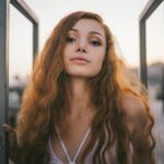 Kobieta o rudych włosach pozuje do zdjecia