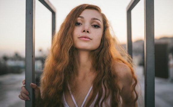 Kobieta o rudych włosach pozuje do zdjecia
