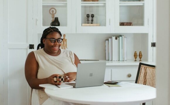 Kobieta o figurze jabłka siedzi przed laptopem