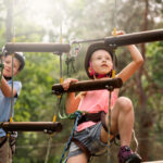 Dwójka chłopców spędająca aktywny weekend w parku linowym
