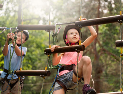 Dwójka chłopców spędająca aktywny weekend w parku linowym