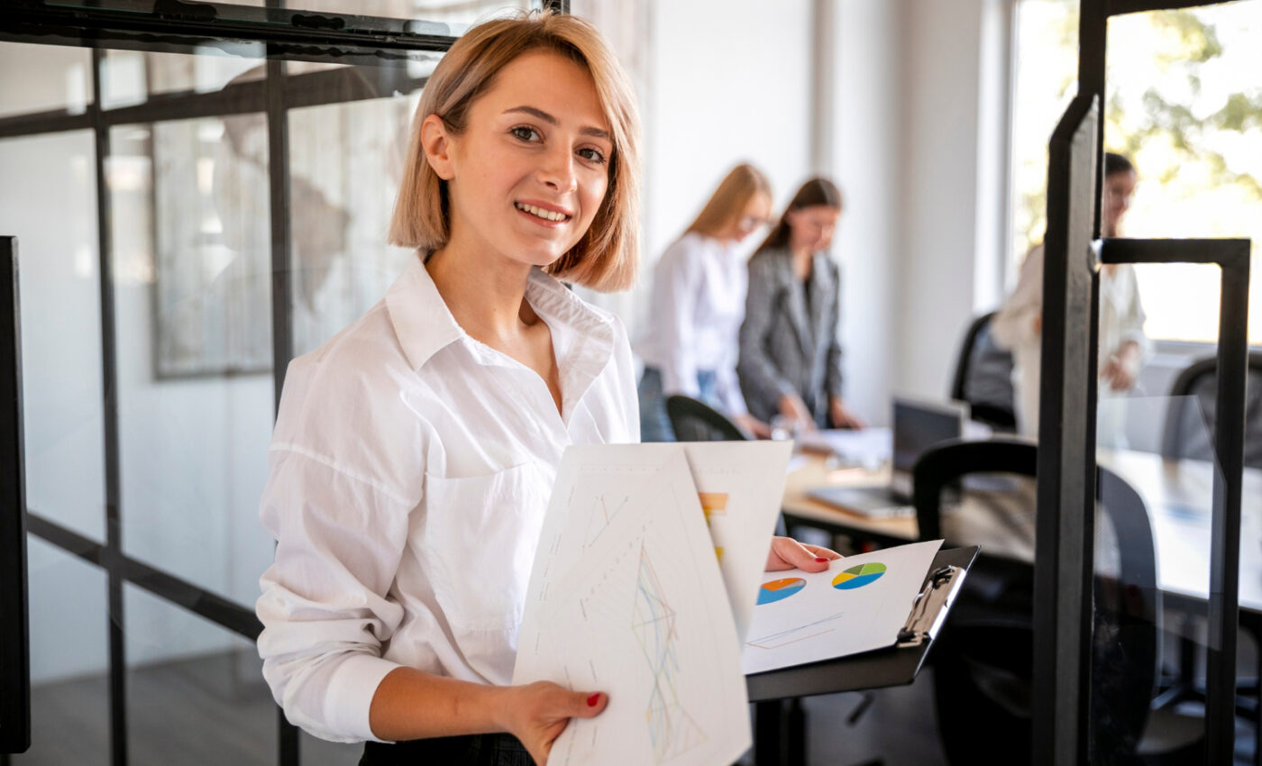 Kobieta w białej koszuli trzyma w rękach plik dokumentów