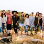 Grupa kobiet obejująca się i stojąca na wzgórzu