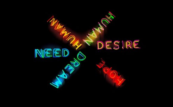 Na czarnym tle najdują się neonowe kolorowe słowa: człowiek, żądza, marzenie, nadzieja, potrzeba (human, desire, hope, dream, need) ułożone w kształt gwiazdy